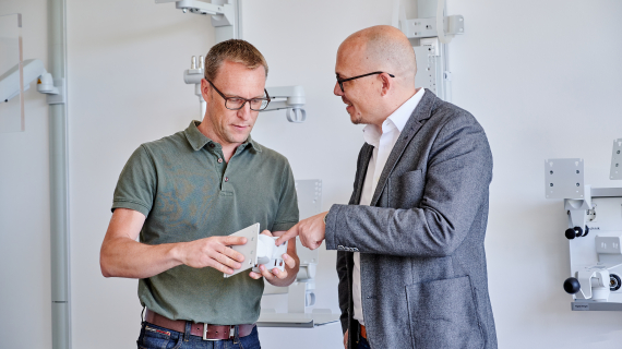 Employee shows a customer a product part