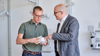 Employee shows a customer a product part